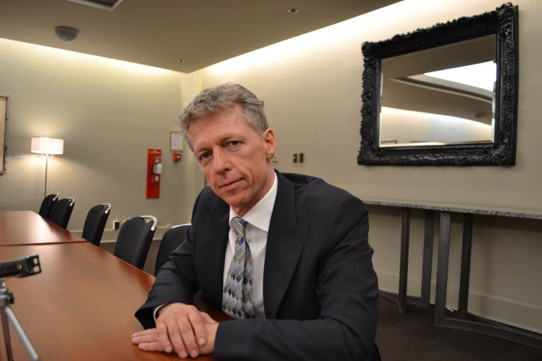 James Orbinski looks into the camera at a conference table in the Jubilee Auditorium