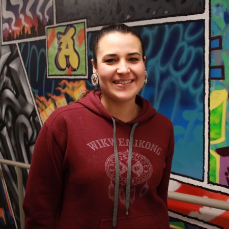 Brianna Olson in front of a mural in iHuman. [Photo: Trevor Chow-Fraser]