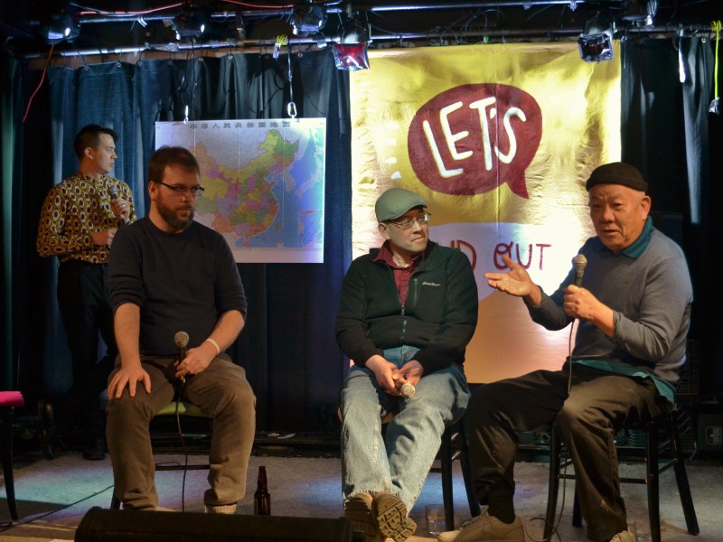 Siu To tells his story on stage while Chris looks at a map of China