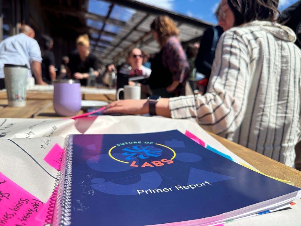 The Future of Labs Primer on a piece of flip chart table at a table during an outdoor discussion at Hollyhock.